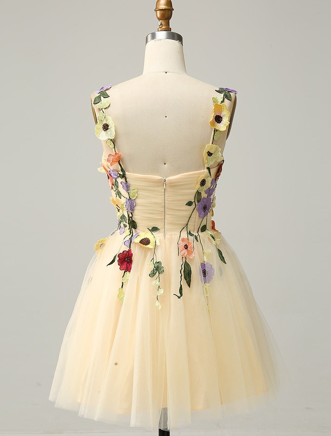 Back view of a short tulle cocktail dress with delicate appliques.