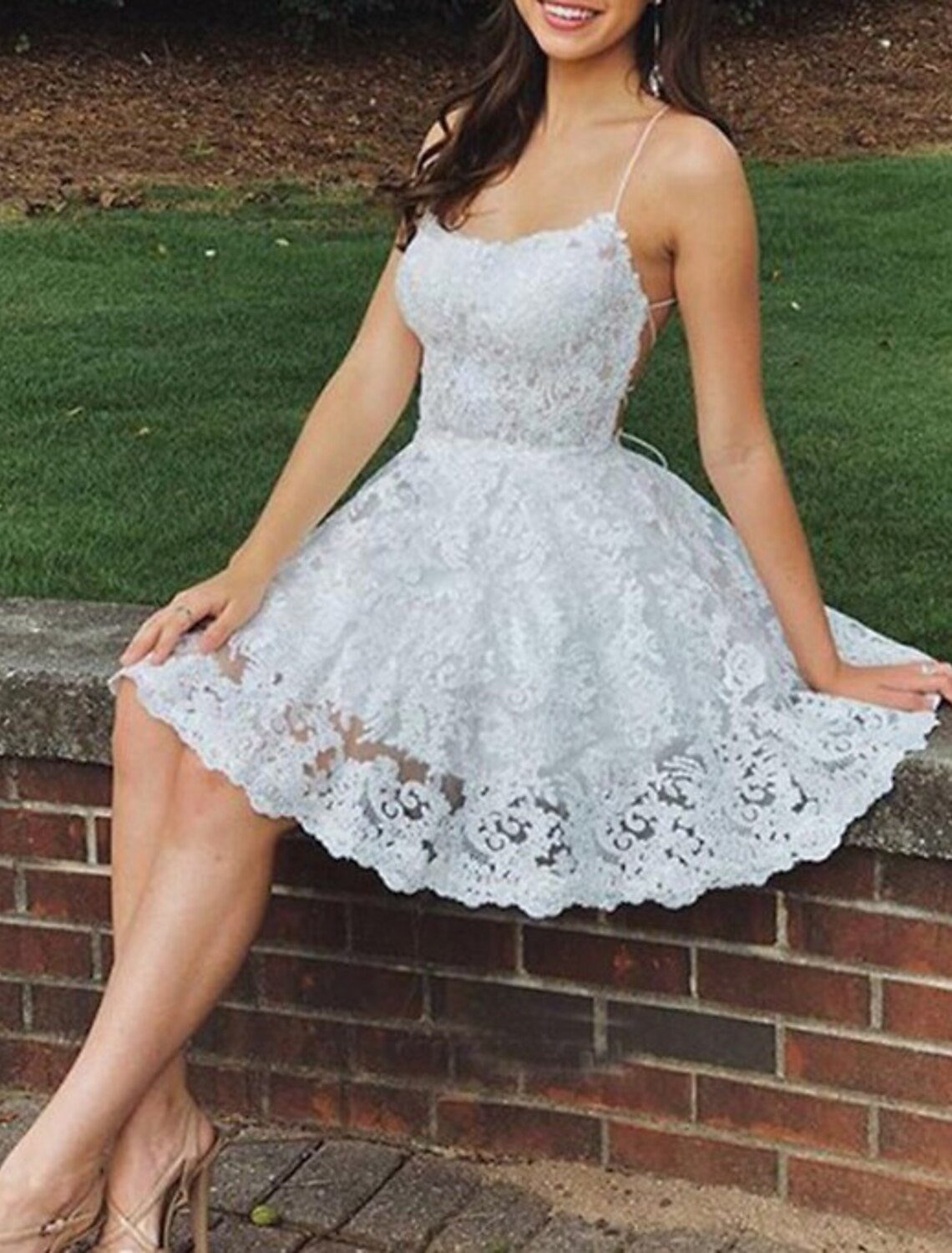 Side profile of sleeveless A-line floral lace dress.