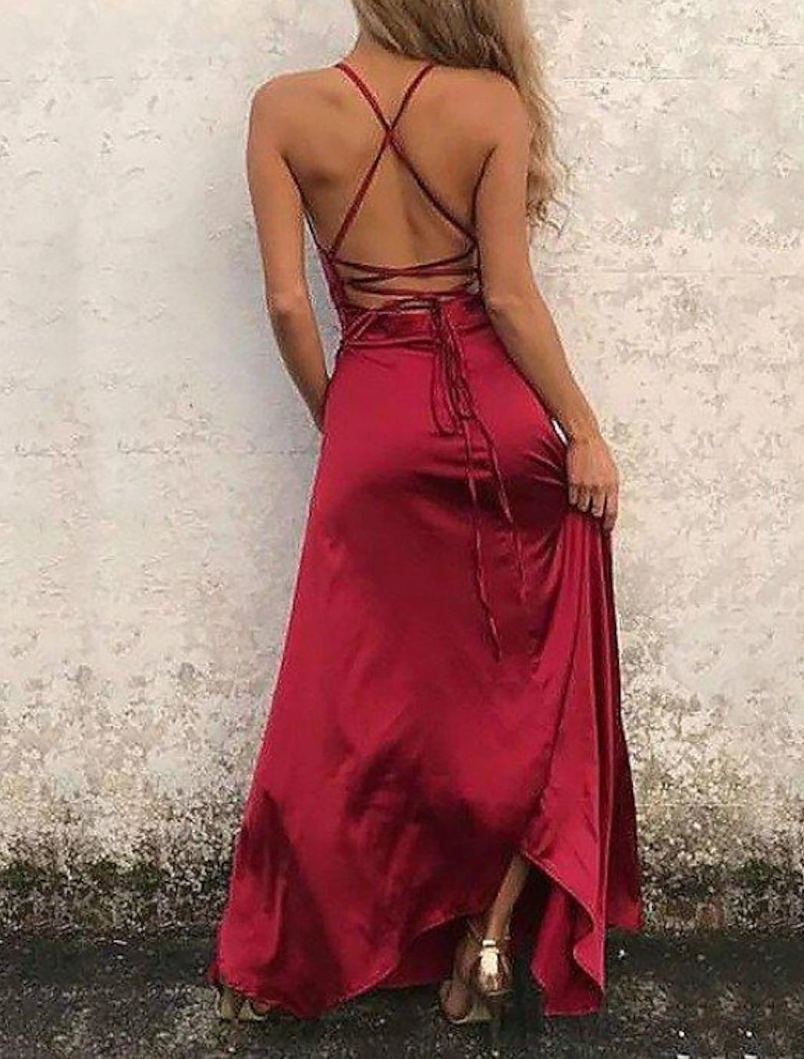 Detail of high slit and ruffles on a floor-length satin dress.