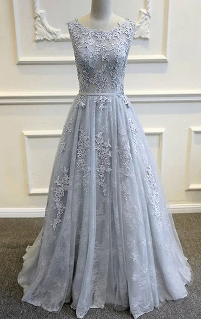 Woman wearing an elegant A-line lace prom dress with spaghetti straps.