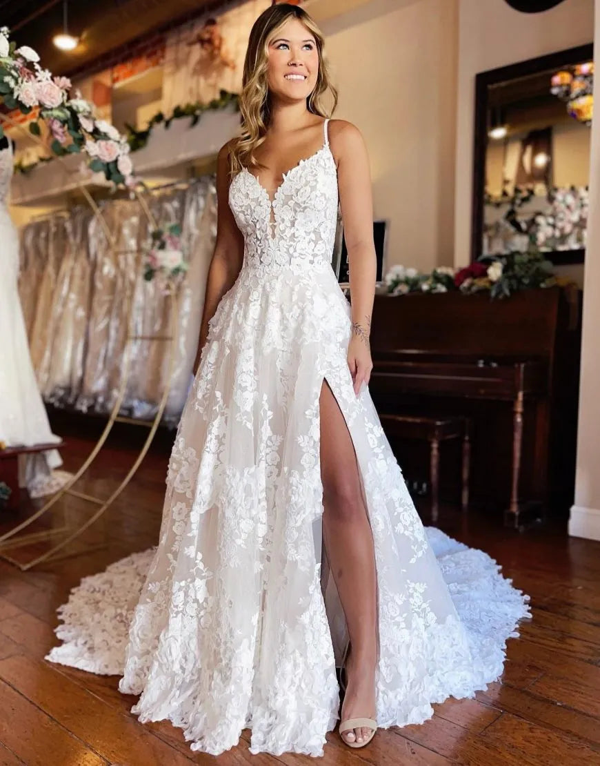 Elegant A-line lace wedding dress with spaghetti straps and a front slit, shown from the front.