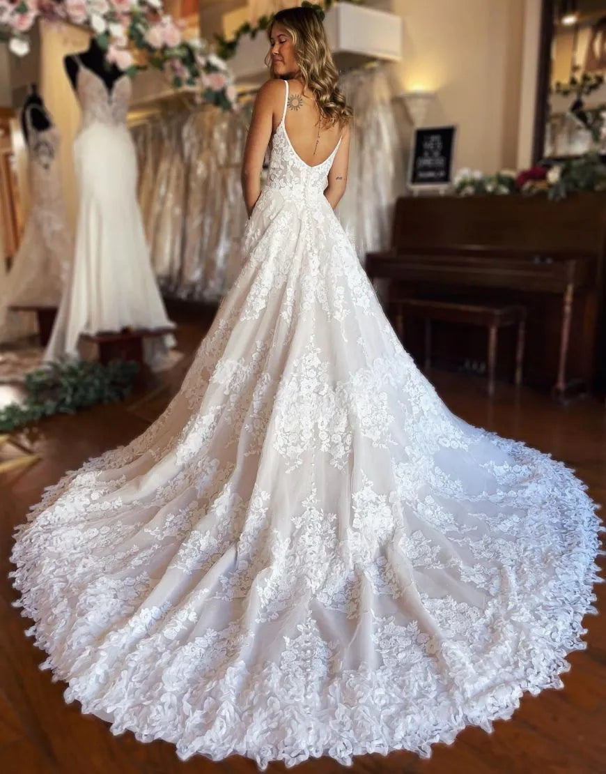 Back view of the A-line lace wedding dress, highlighting the delicate straps and flowing train.