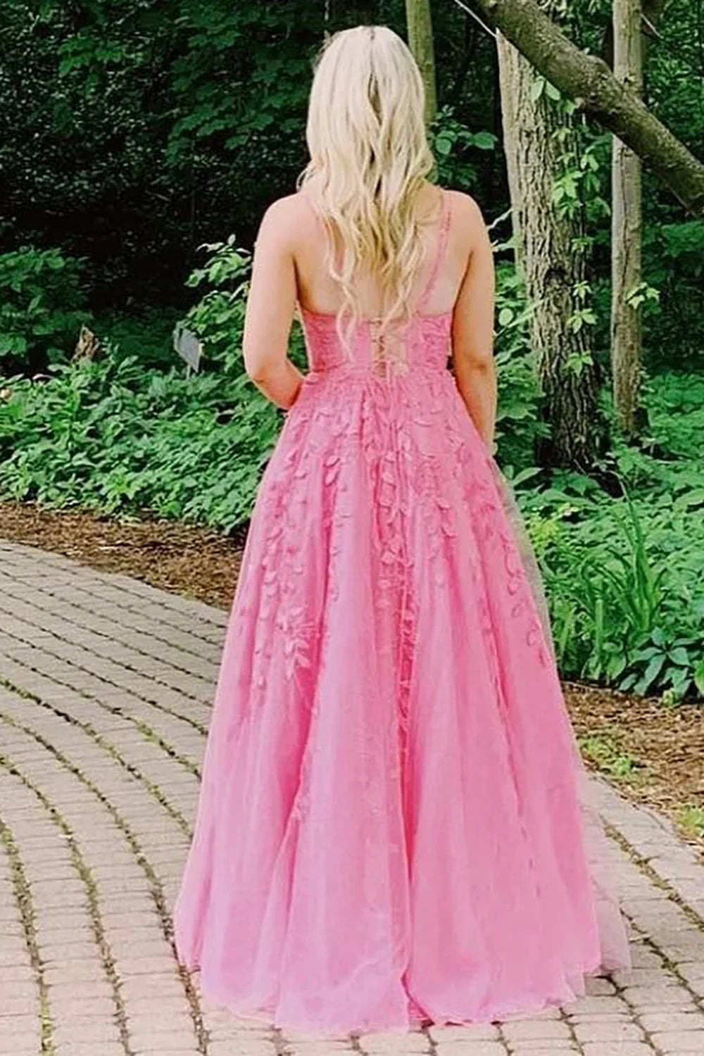 Back view of a long pink A-line evening gown with appliques.