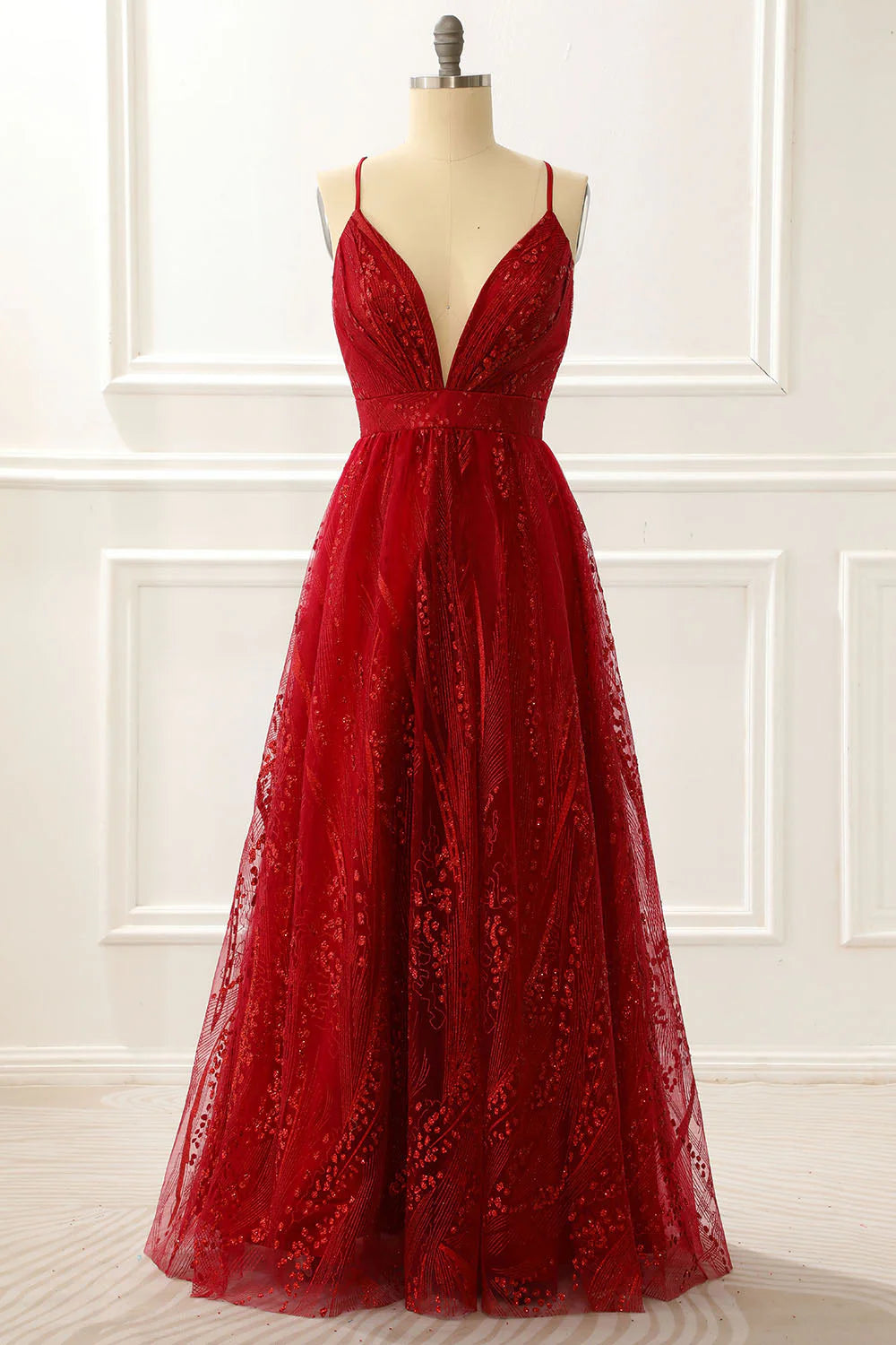 Model wearing a burgundy A-line spaghetti strap princess long prom dress, front view.