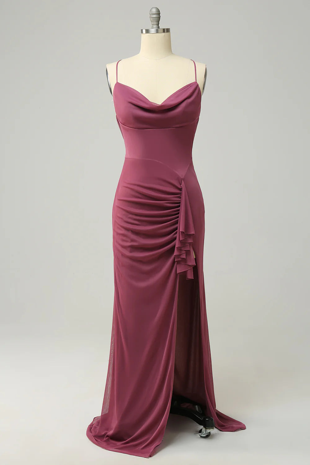 Woman posing in an elegant desert rose spaghetti strap prom dress with a high slit.