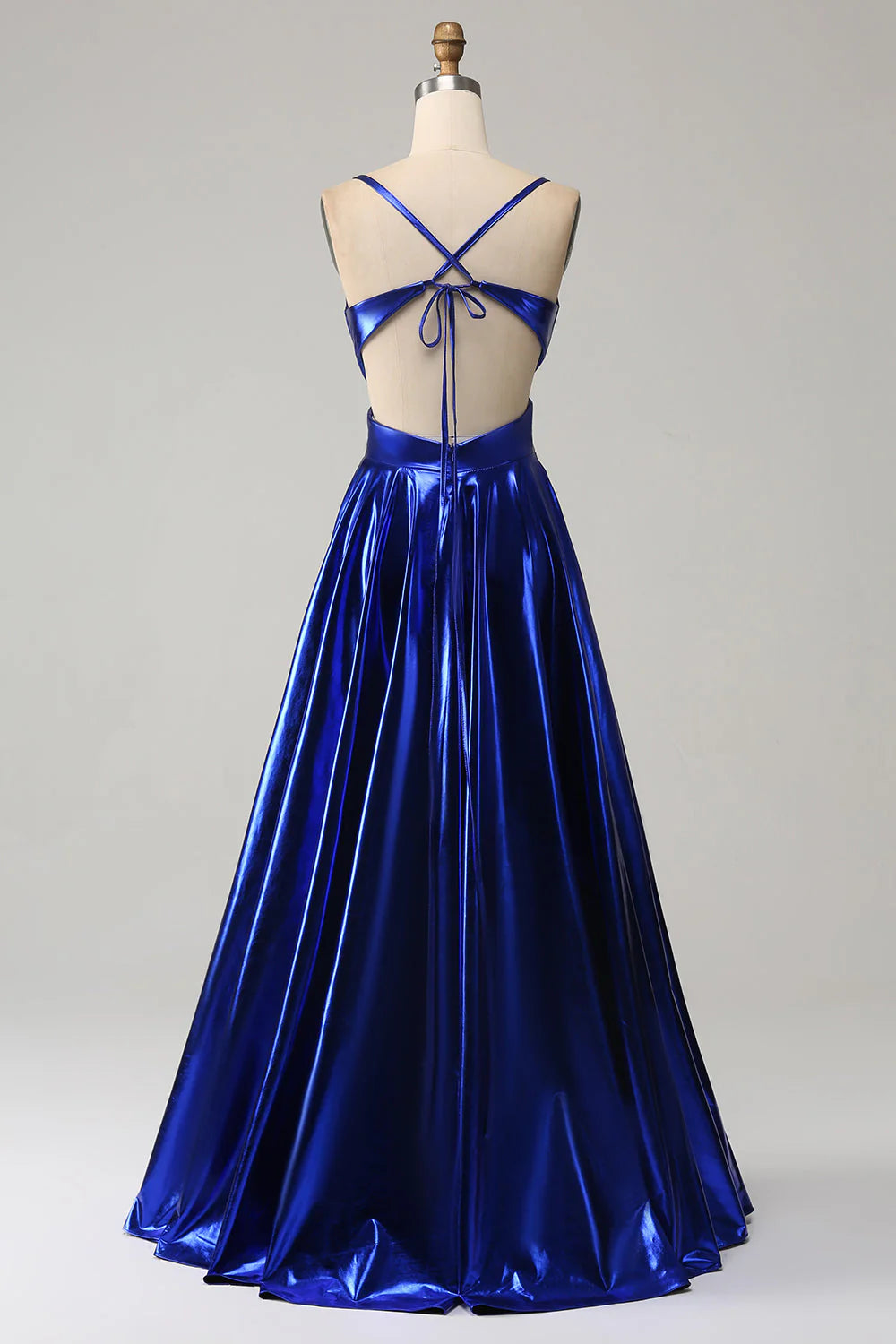 Side view of a model in a royal blue A-line prom dress with spaghetti straps and a high slit.