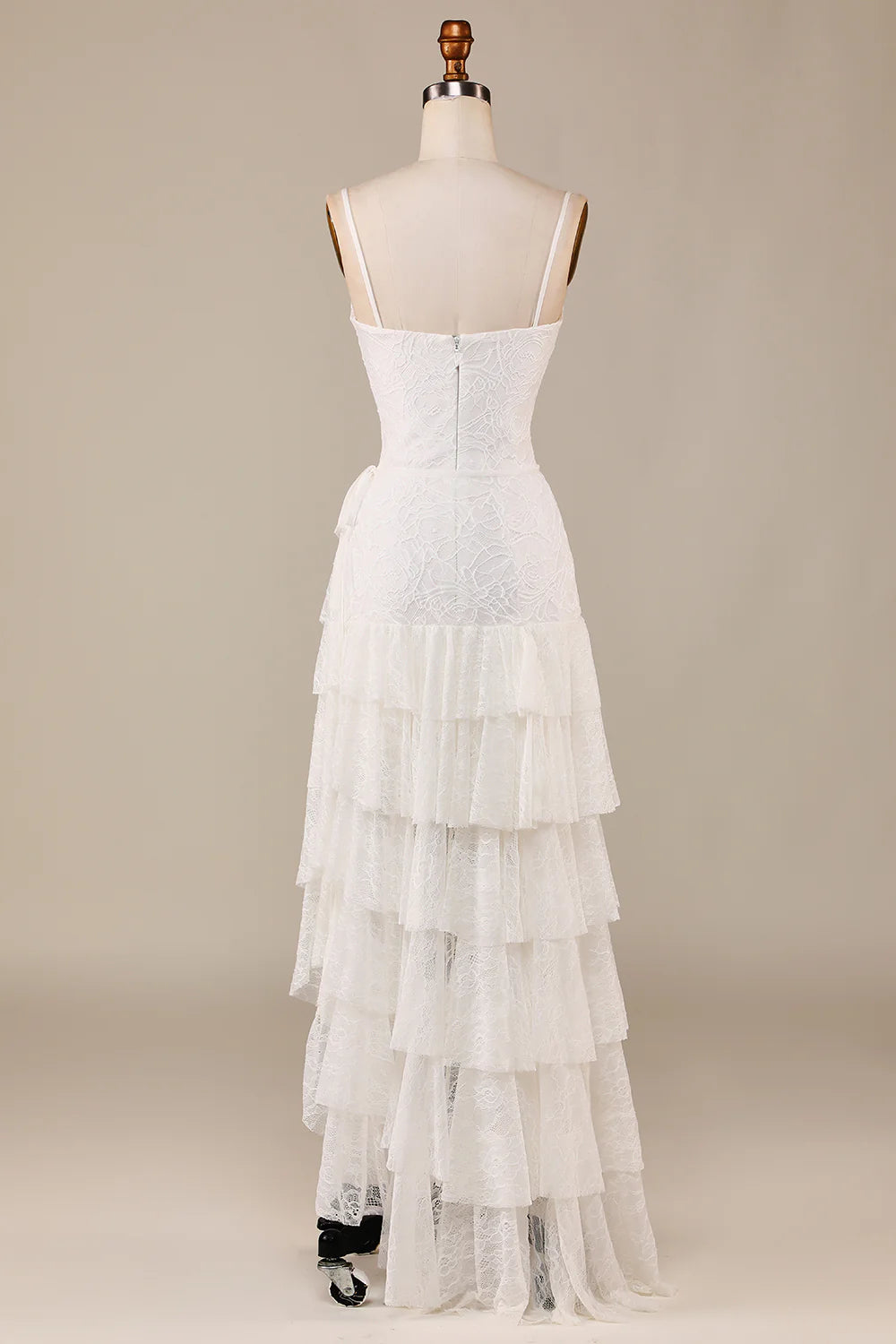 Close-up of delicate lace and tiered skirt on an ivory bridal gown.