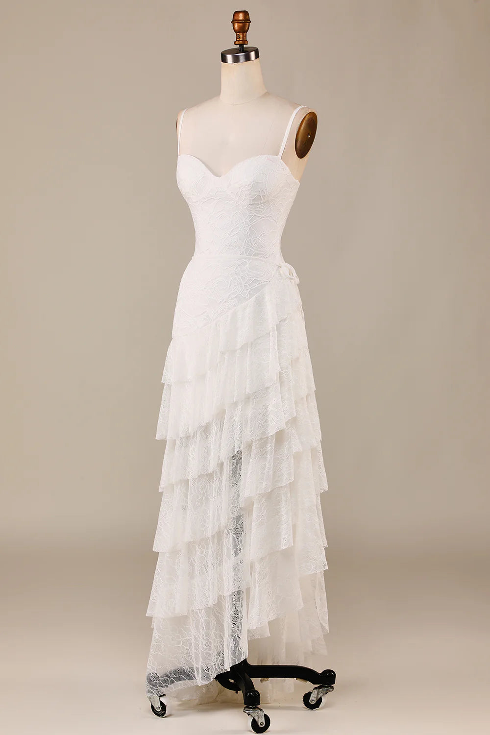 Side view of a bride wearing an ivory tiered lace wedding dress.