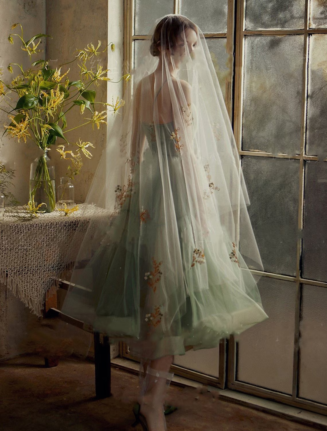 Minimalist A-line wedding guest dress featuring a sash and flowing tulle skirt.