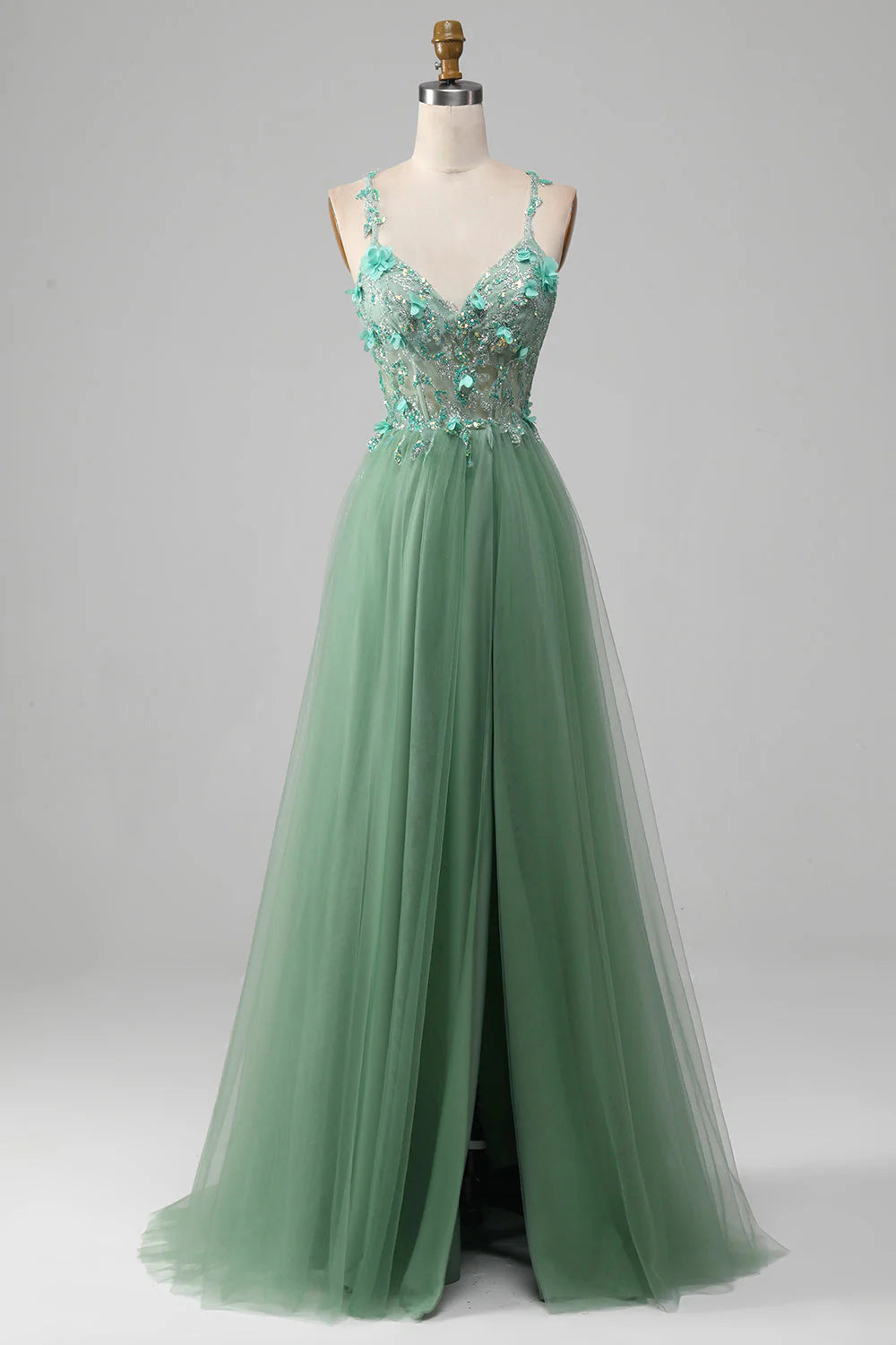 Green A-line prom dress with spaghetti straps and appliques.