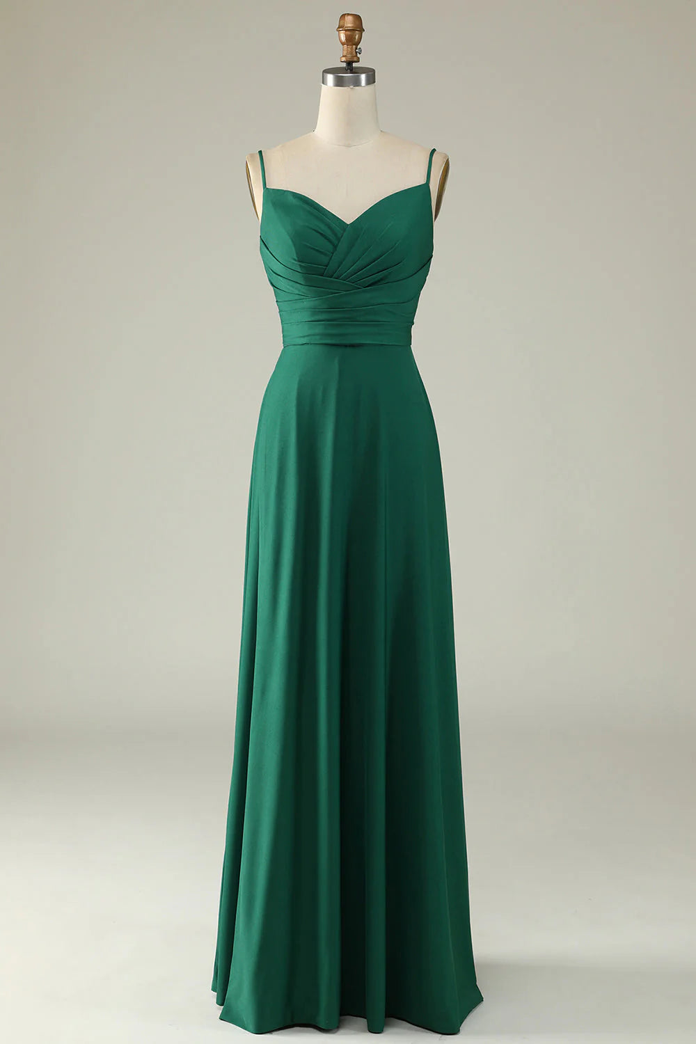 Model wearing an elegant dark green spaghetti strap long prom dress, front view.