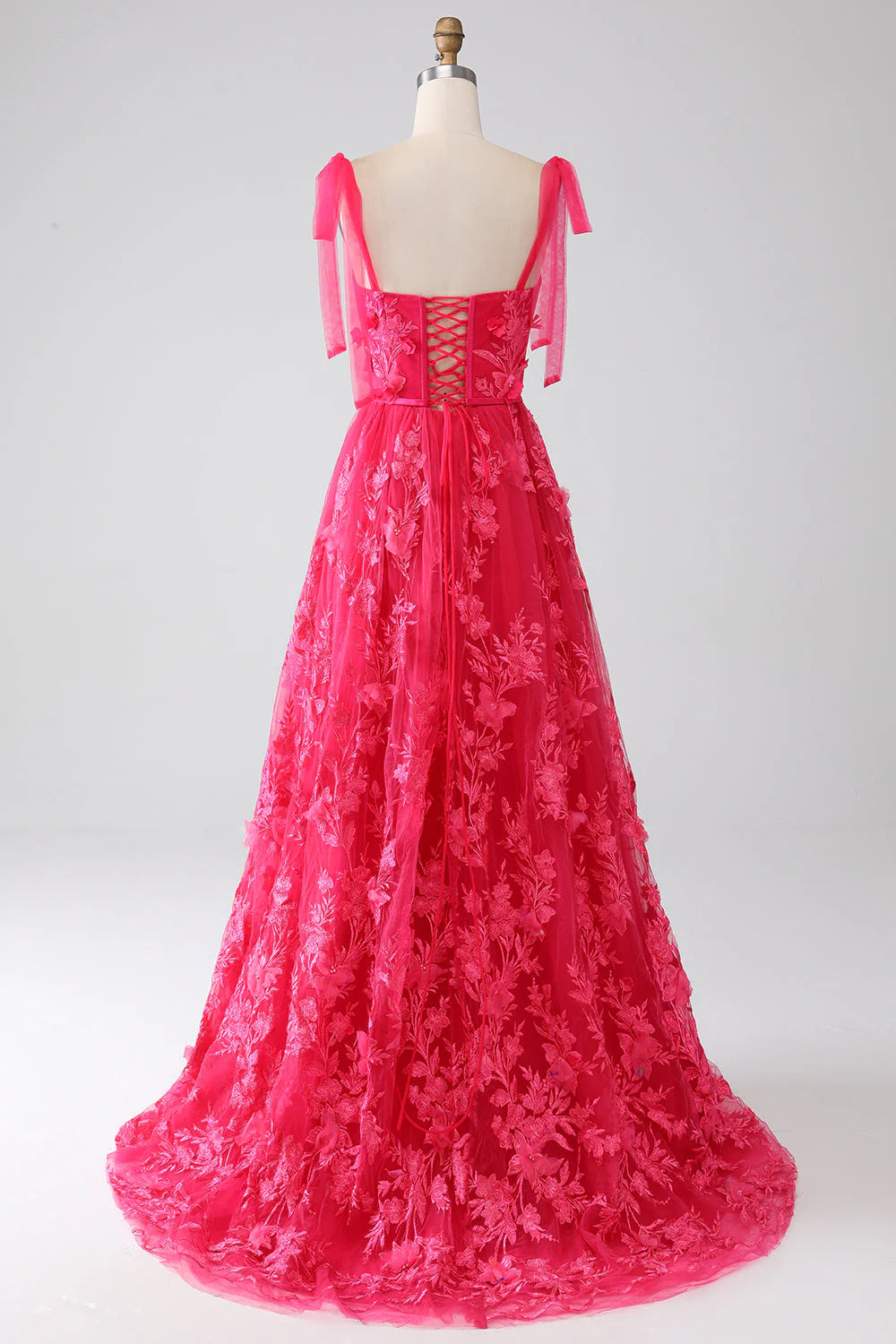 Model showcasing the side slit of a fuchsia long A-line gown.