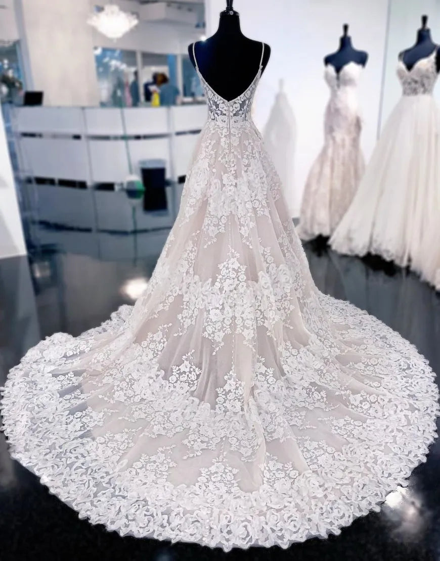 Back view of an A-Line wedding dress featuring spaghetti straps, appliques, and a flowing court train.