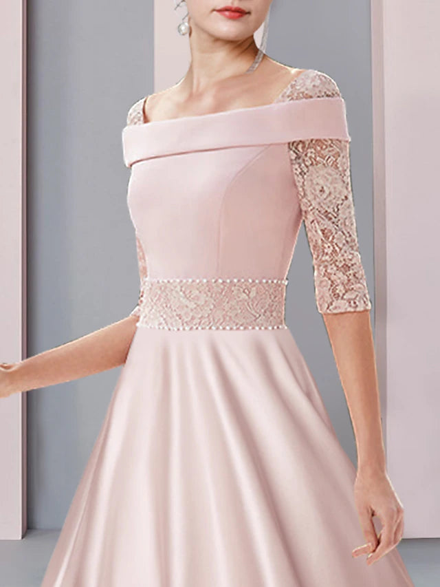Close-up of satin and lace details with pearls on a formal dress.