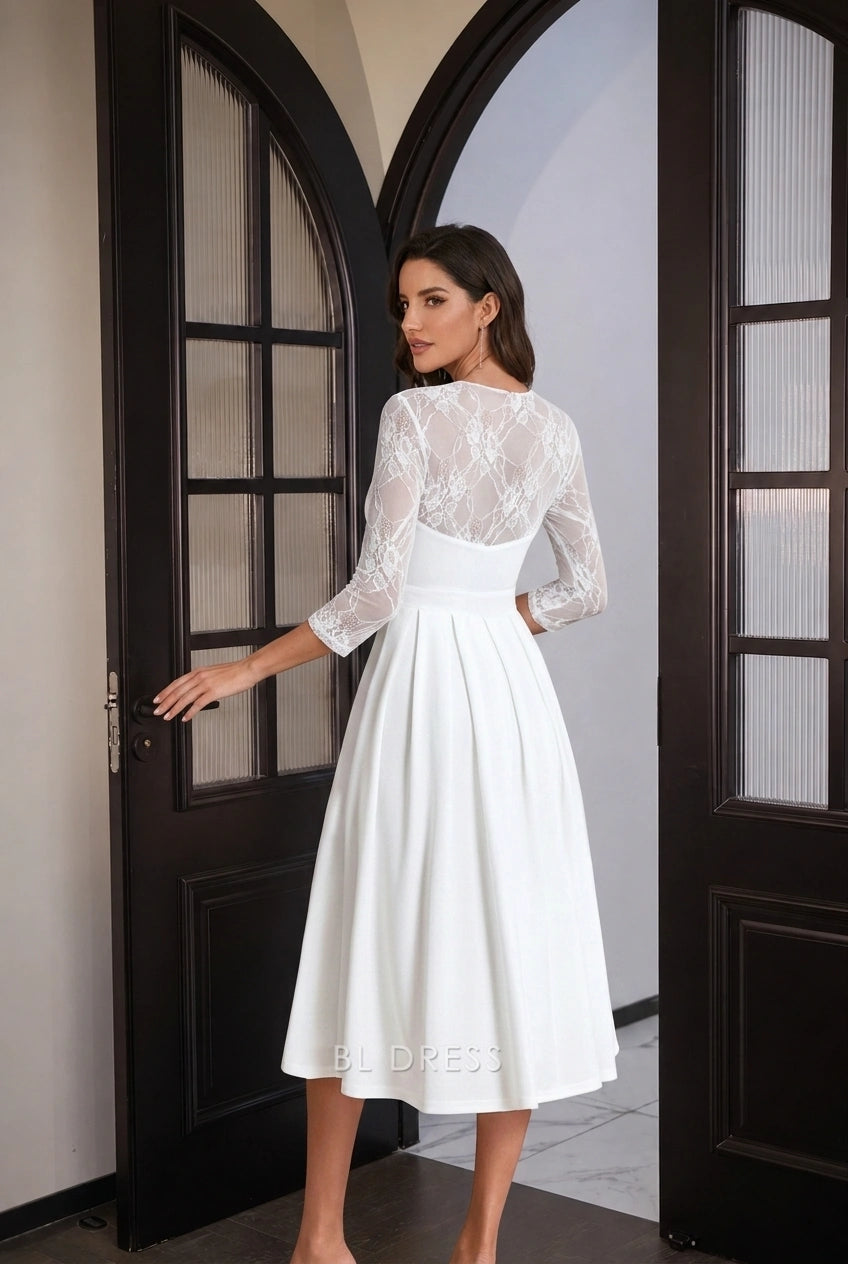 Side view of white A-line midi dress, showing lace sleeves and pleated skirt.