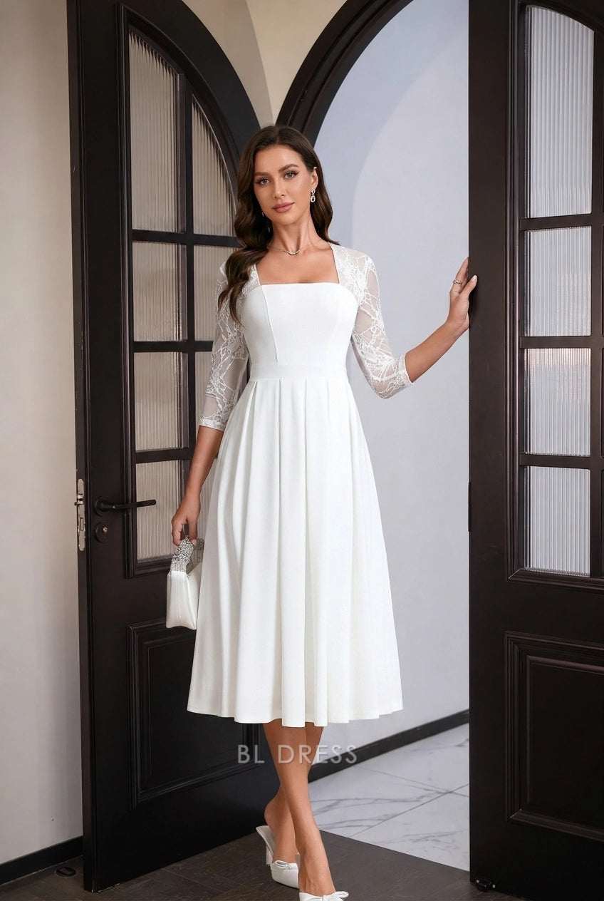 Detailed view of pleated skirt and midi length of white formal dress.