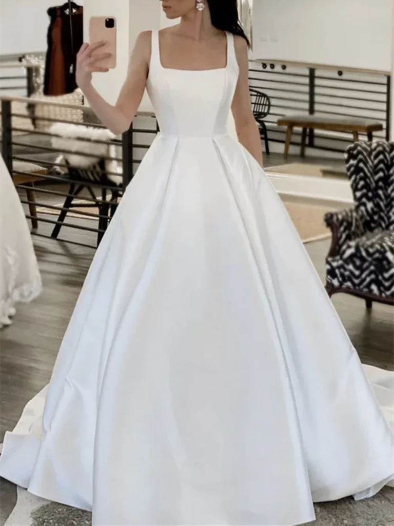 Elegant A-line wedding dress with a square neckline made from white satin fabric.