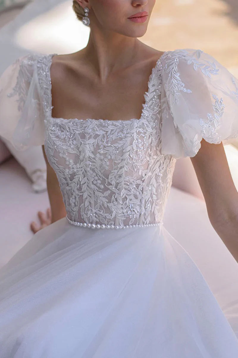 Close-up of the lace appliques on the short sleeve wedding dress.