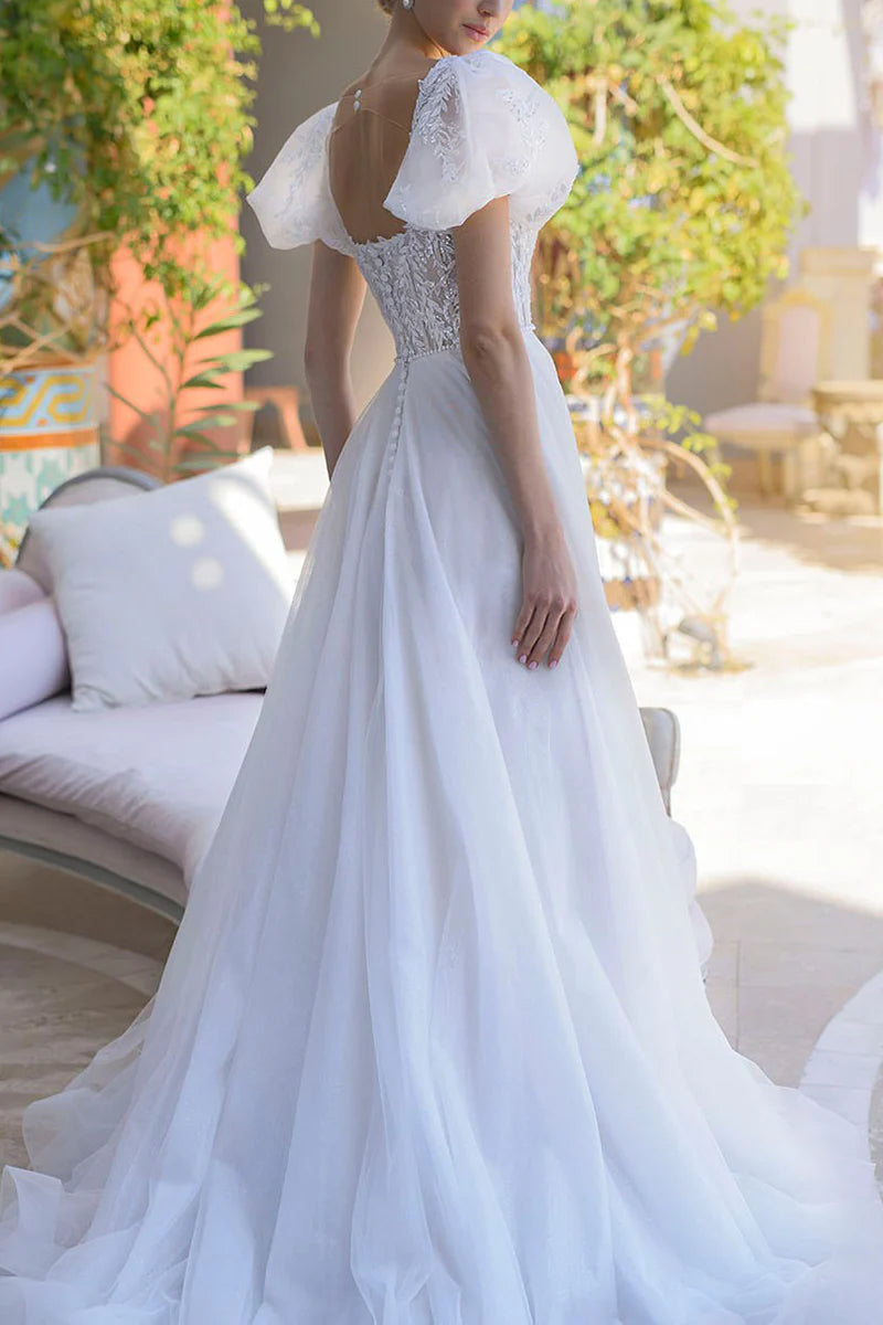 Side view of A-line bridal gown showcasing short sleeves and flowing skirt.