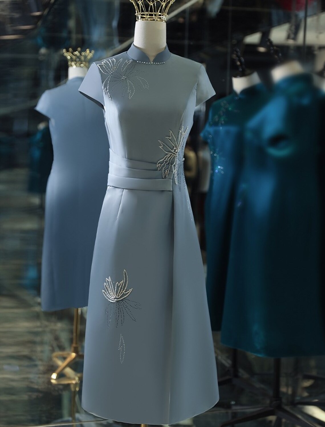 Elegant A-line satin tea length cocktail dress with stand collar and appliques.