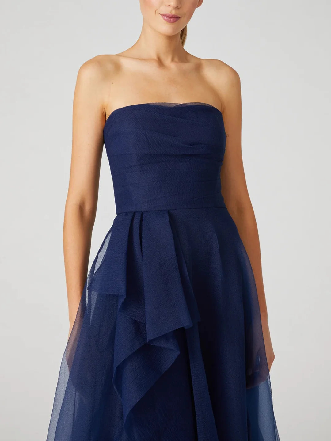 Side view of a navy A-line strapless formal gown.