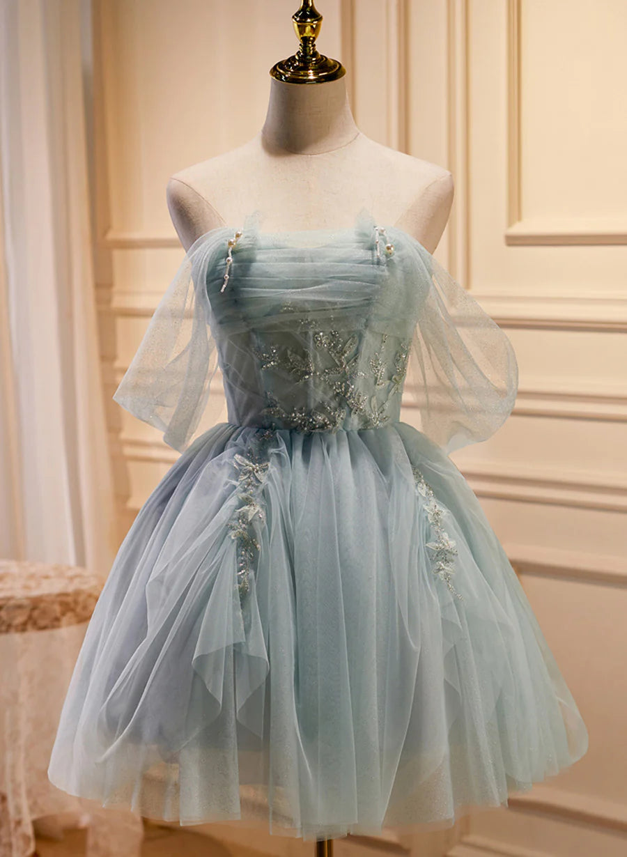 Model wearing a light green tulle beaded short prom dress, front view.