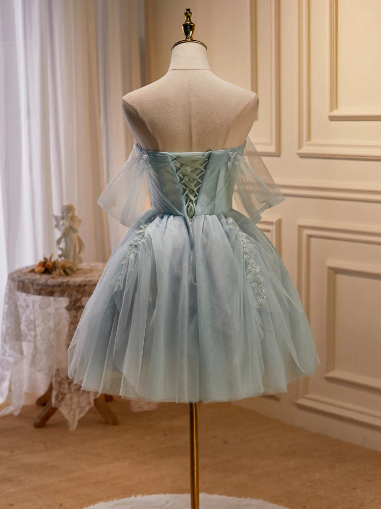 Close-up of the beaded bodice and tulle skirt of the light green dress.