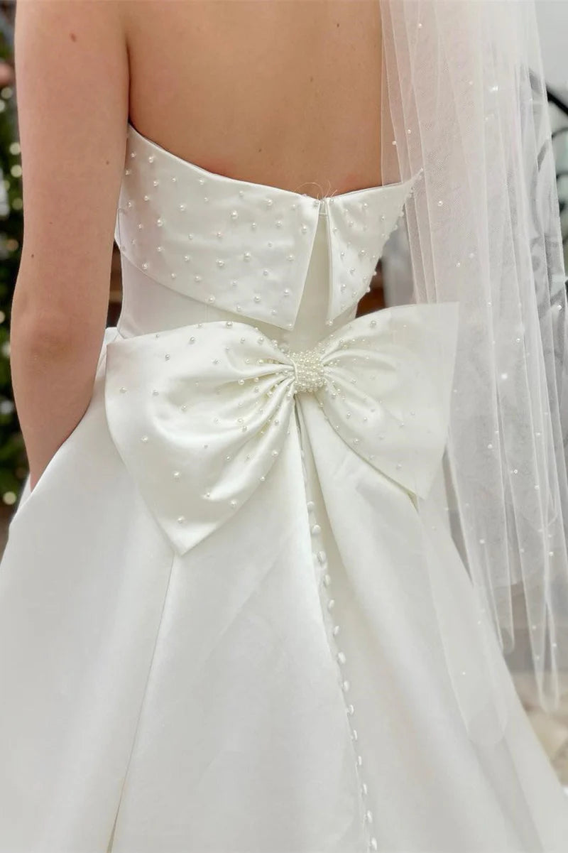 Full length view of a bride wearing the A-Line strapless pearl wedding dress.