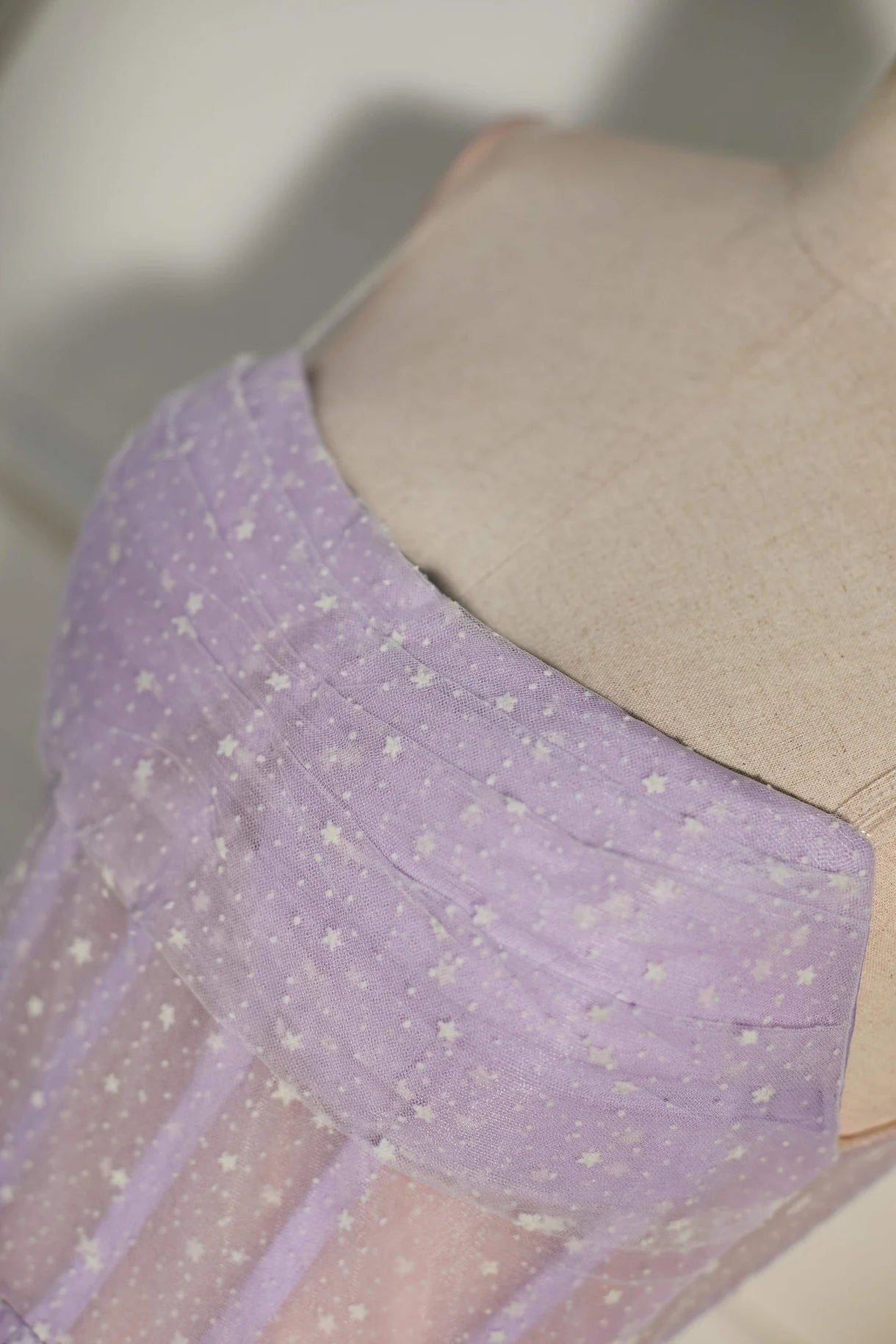 Side profile of the strapless dot tulle mini dress.