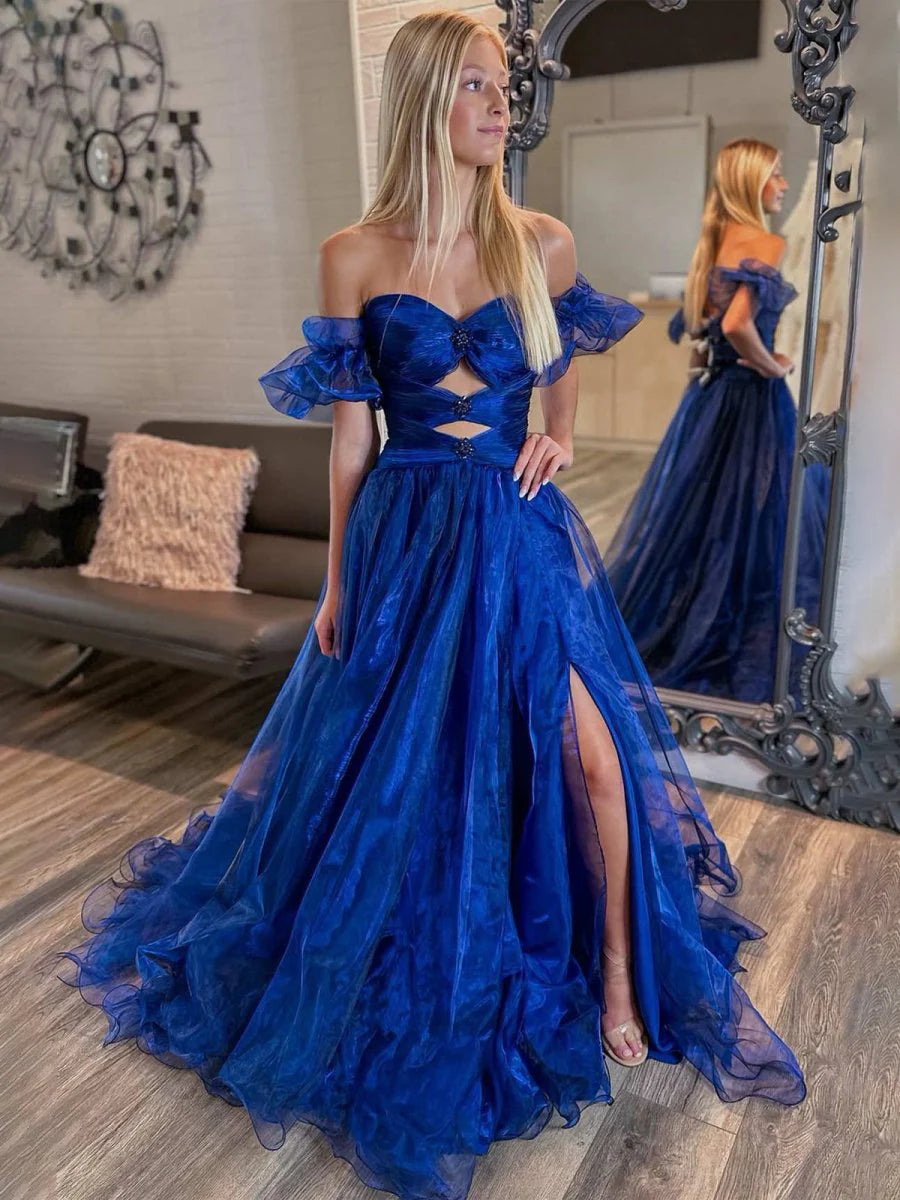 Model wearing a royal blue strapless long prom dress with keyhole detail and balloon sleeves, front view.