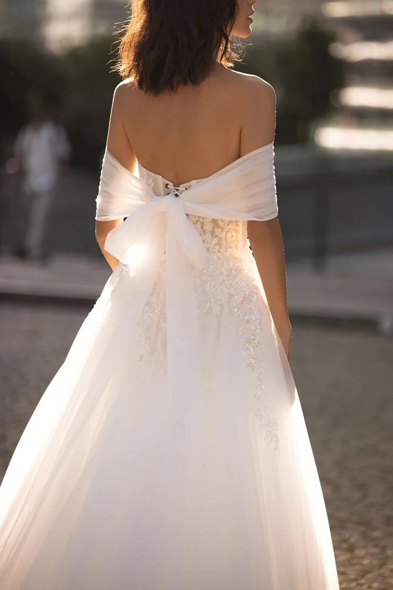 Elegant A-Line bridal gown with lace details, side view.