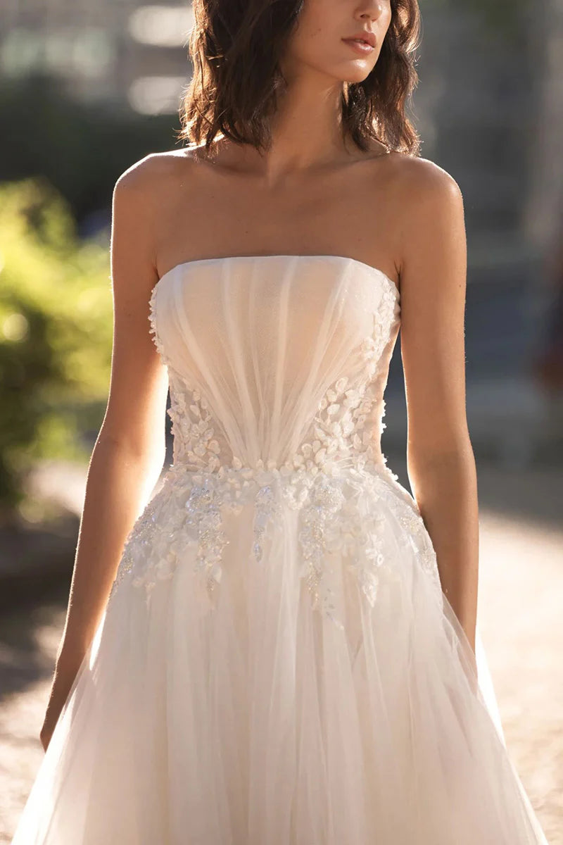 Strapless wedding dress featuring delicate lace appliques, back view.