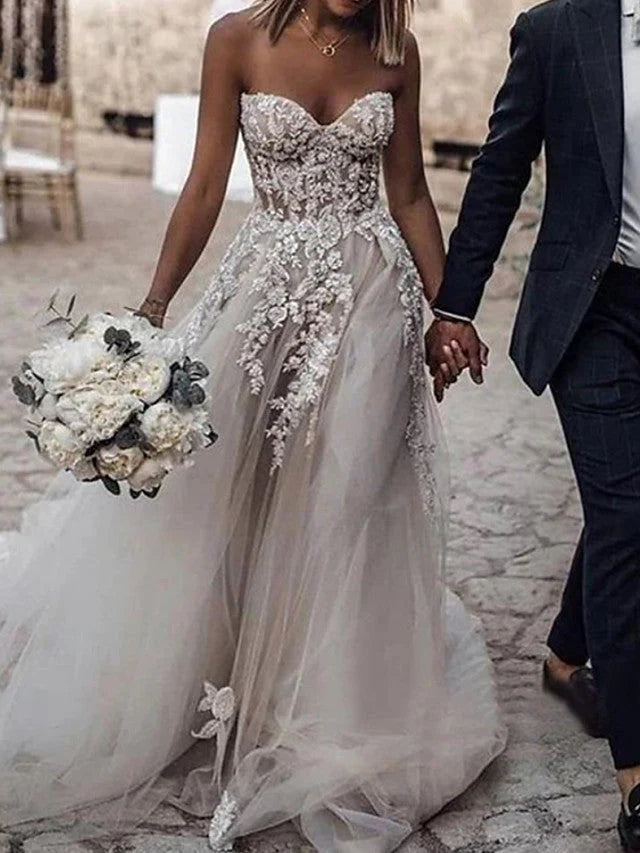 Elegant A-Line strapless wedding dress with lace and tulle, long sweep train.