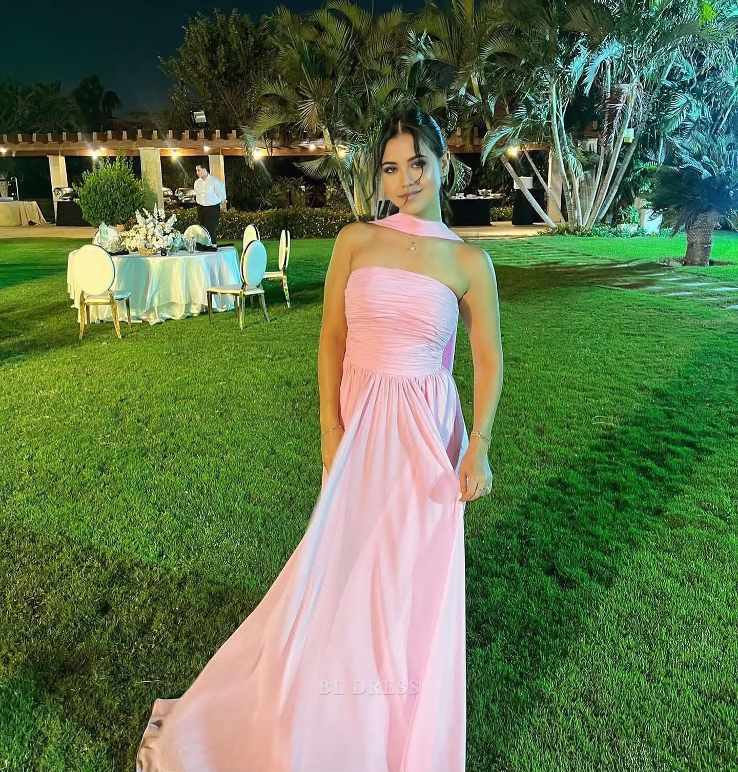 Model wearing an elegant A-line strapless pink chiffon formal dress.