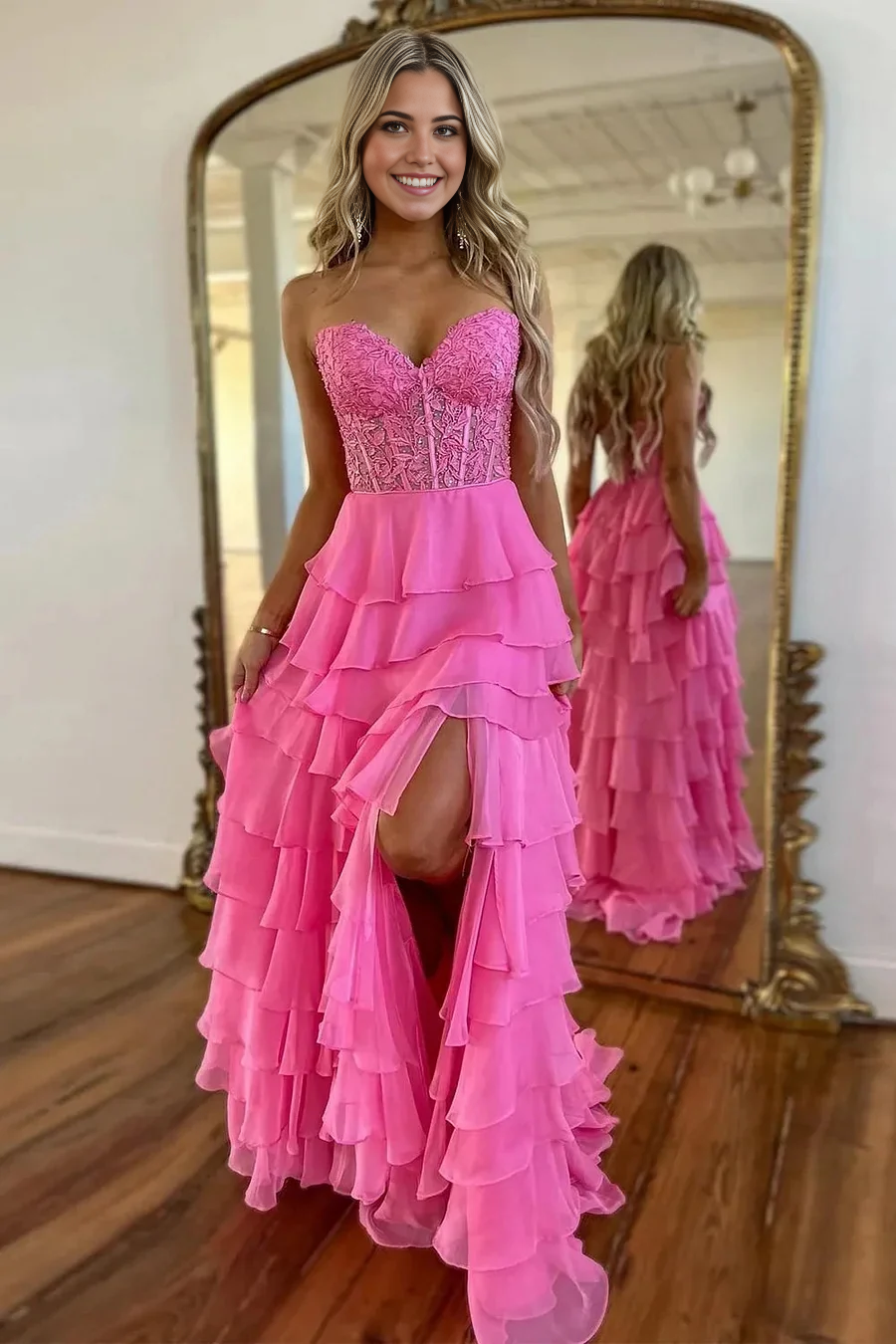 Model wearing an elegant pink strapless A-line ruffle tiered chiffon long prom dress.