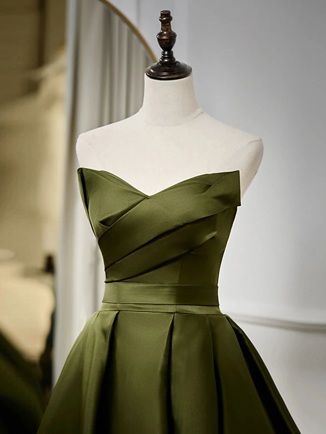 Side profile of a woman wearing a black floor-length strapless satin gown.