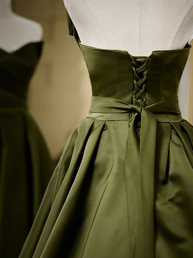Close-up of the pleated detail on a black strapless A-line dress.