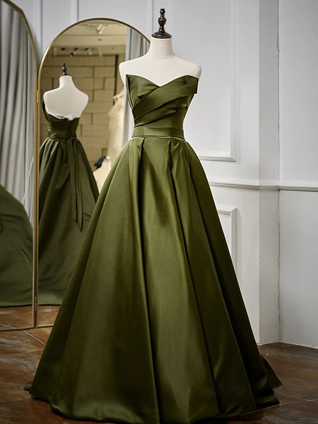 Full length view of a black strapless evening dress with a flowing A-line skirt.