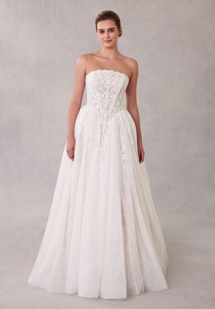 Side profile of the white strapless bridal dress with flowing tulle.