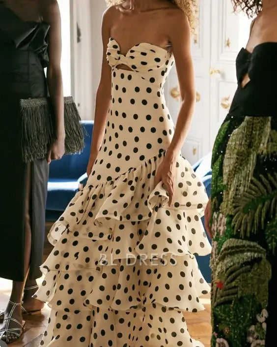 Woman wearing an elegant A-line strapless polka dot formal dress.