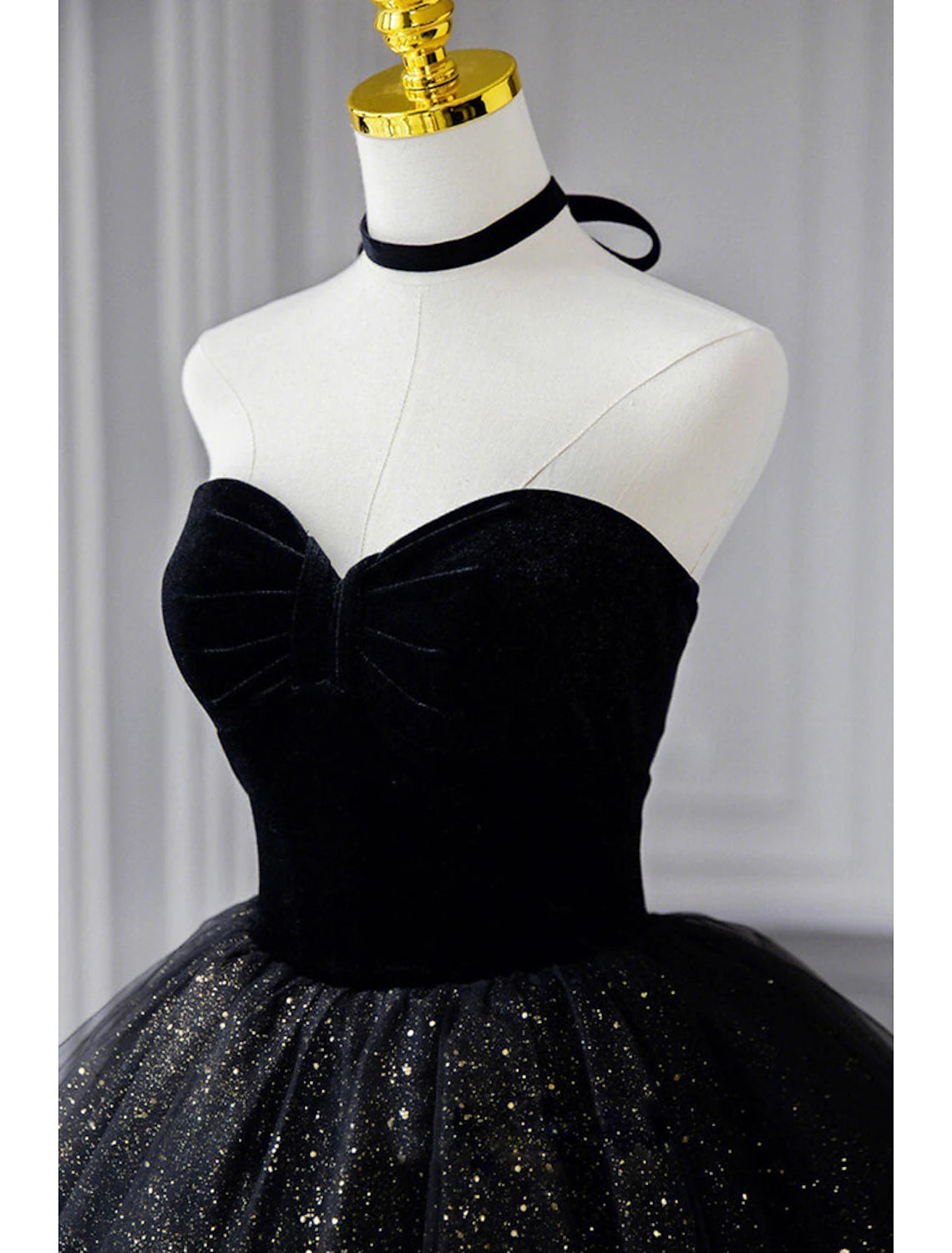 Side view of the black A-line strapless prom dress, highlighting the floor-length skirt.