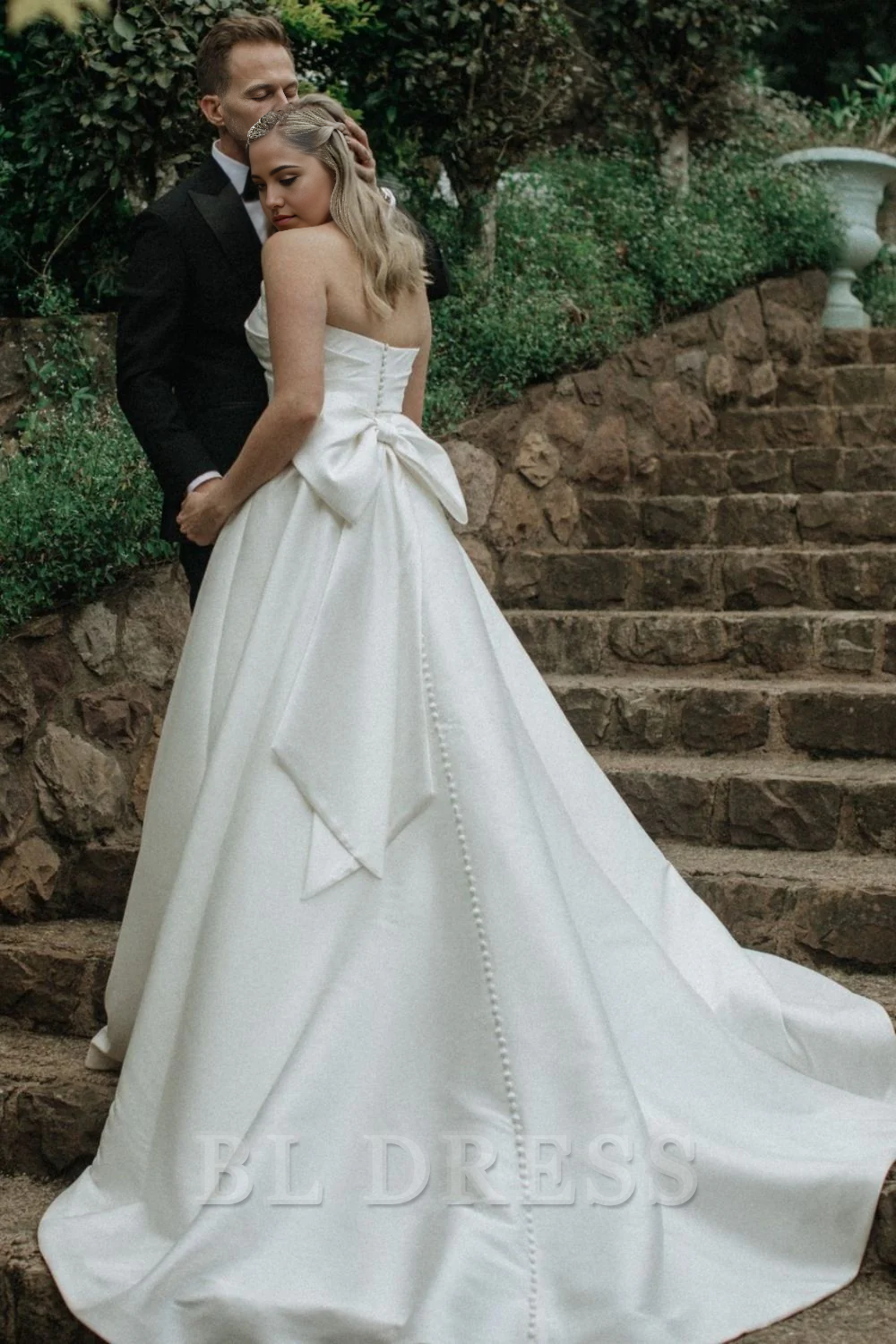 Side view of the elegant A-line strapless white satin long wedding dress.