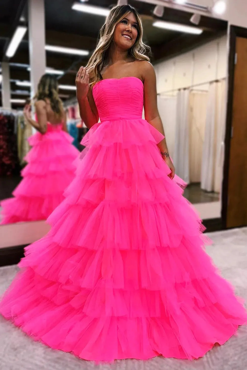Model wearing an elegant A-line strapless long prom dress with cascading ruffles.