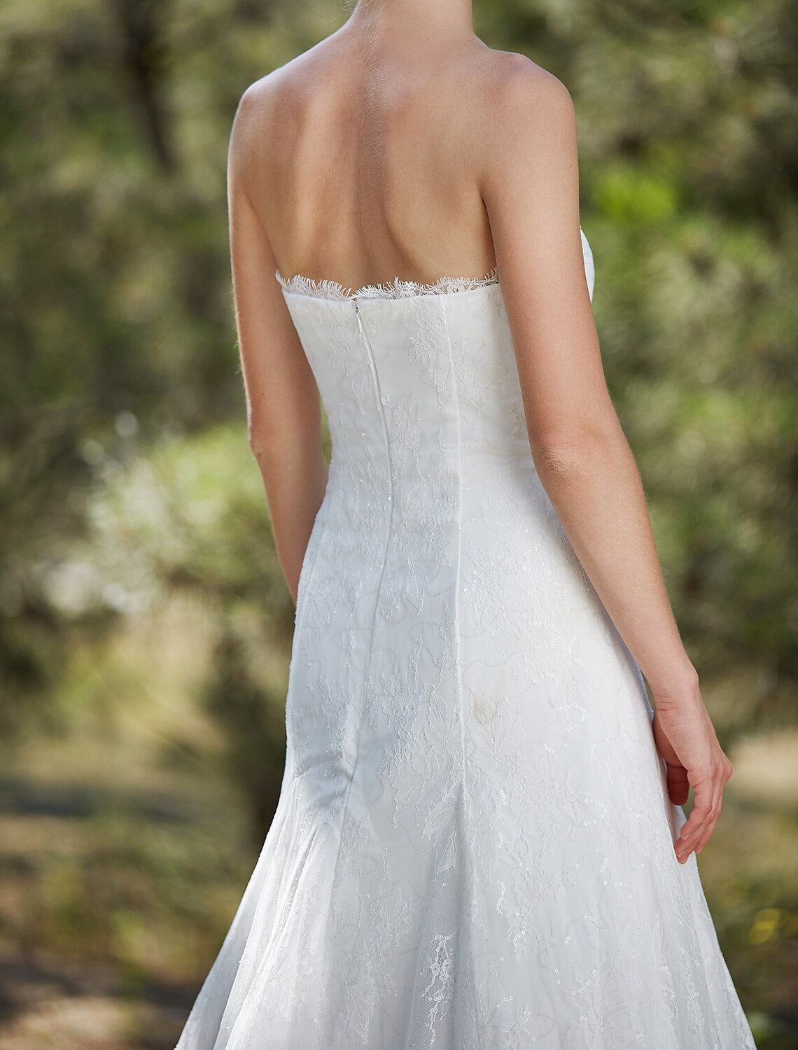 Full length view of a bride wearing an A-Line strapless satin gown.