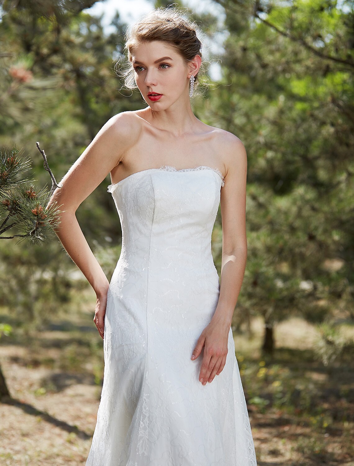 Bride posing in an A-Line satin wedding dress with intricate lace.