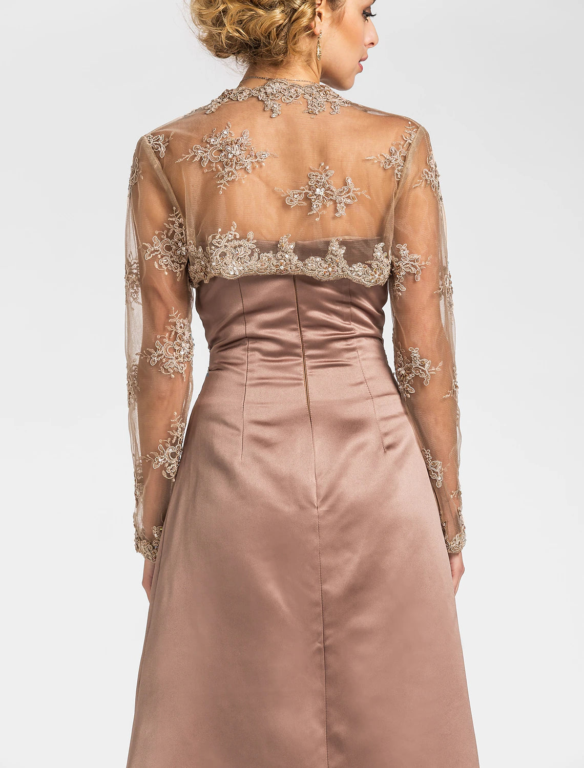 Close-up of criss-cross beading and lace appliques on satin fabric.