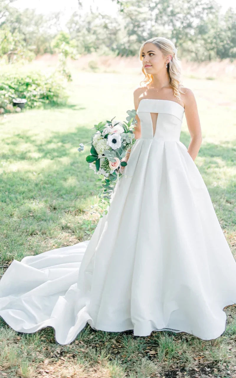 Elegant A-line strapless satin wedding dress with button back and chapel train.