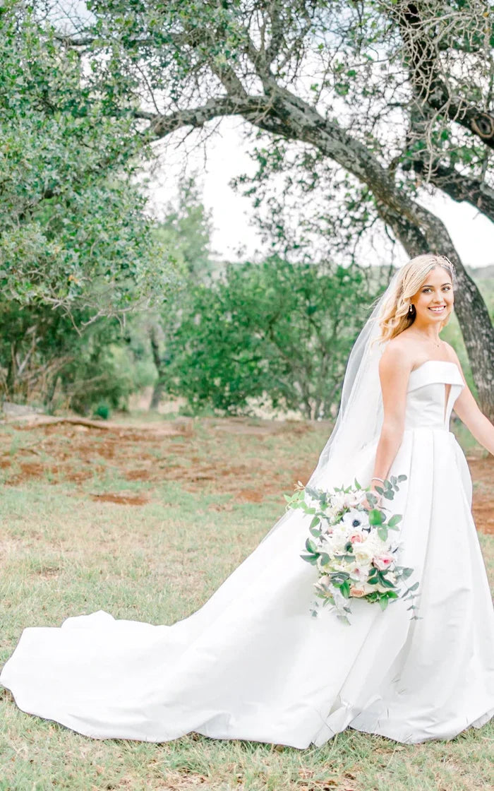Side view of A-line strapless satin wedding dress with chapel train.
