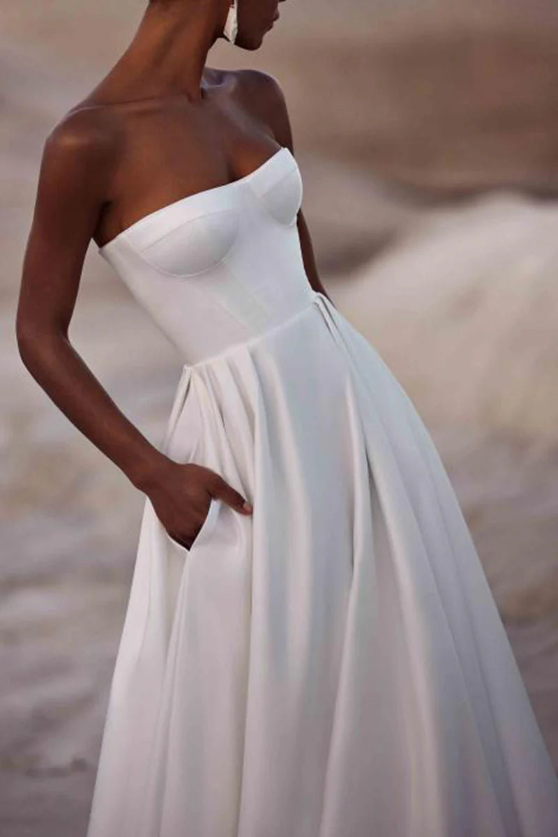 Full-length view of an A-Line strapless satin wedding dress with a court train.