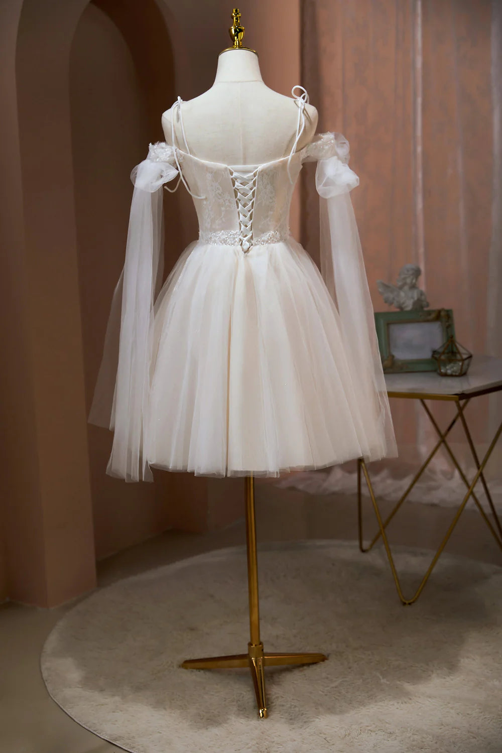 Side view of blush A-line tulle dress with intricate appliques.